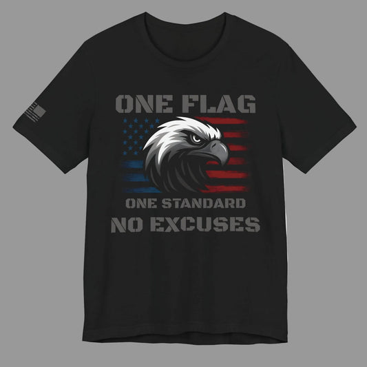 Flat lay of black ‘One Flag One Standard No Excuses’ t-shirt with American flag and eagle graphic and flag on the sleeve, on a grey background