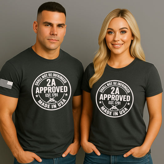Man and woman wearing charcoal black ‘2A Approved – Shall Not Be Infringed’ t-shirts with circular stamp graphic and American flag on the sleeve, on a gray studio background