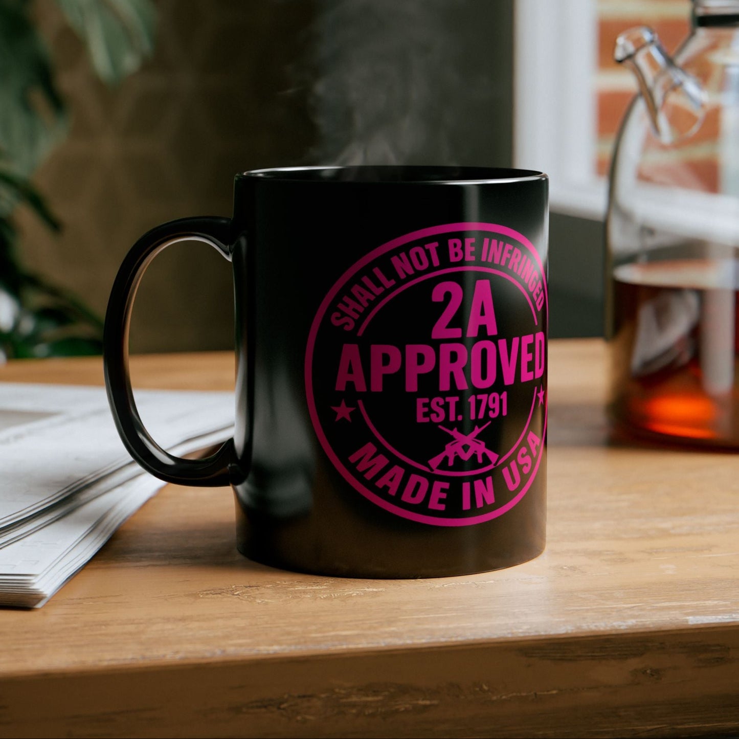 Black ceramic mug with pink “2A Approved” design on a wooden kitchen counter with steam