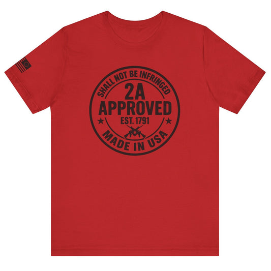Red ‘2A Approved – Shall Not Be Infringed’ t-shirt with circular stamp graphic and American flag on the sleeve on a white background.