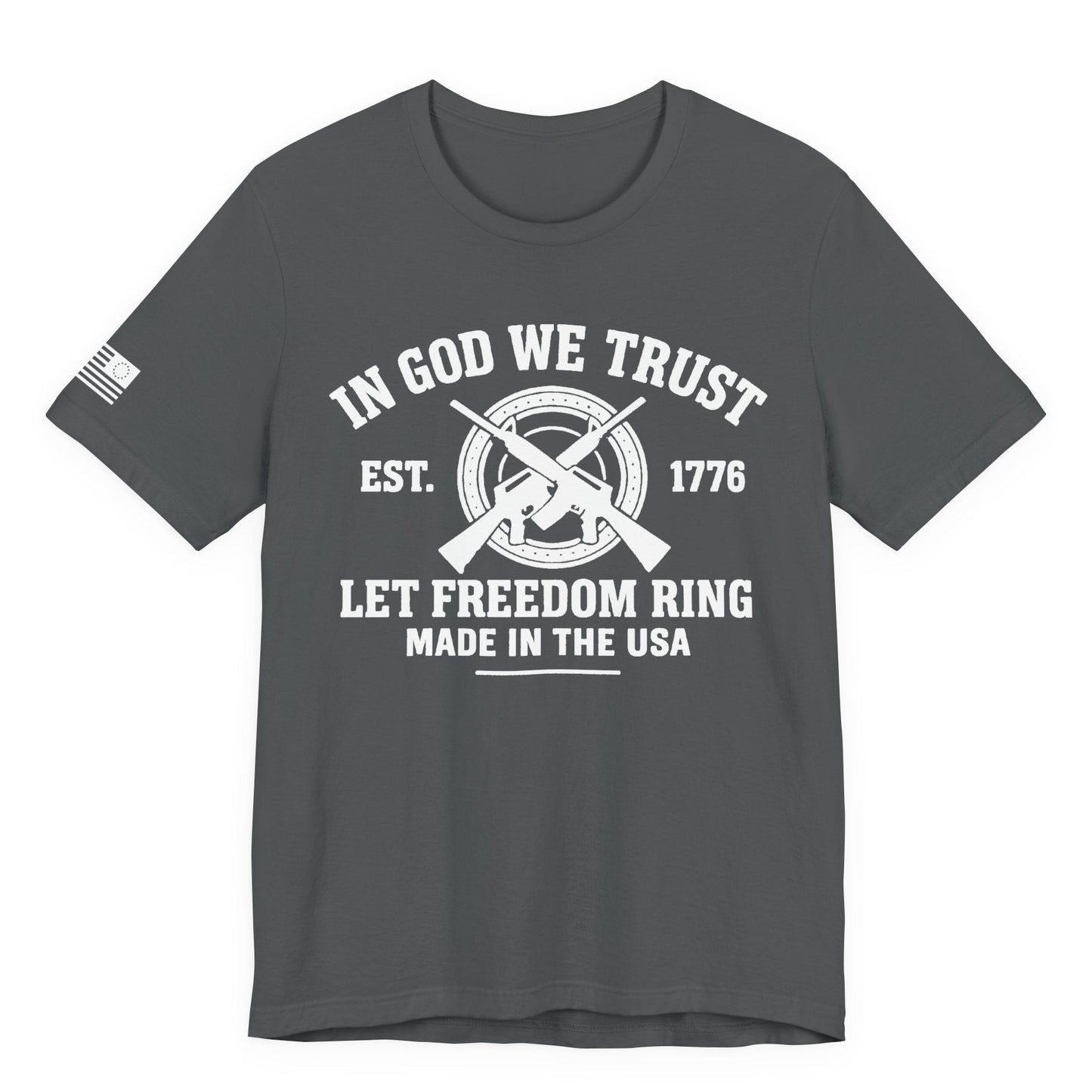 Grey  unisex t-shirt with white “IN GOD WE TRUST” crossed-rifles graphic and “LET FREEDOM RING” text, left-sleeve flag graphic, white background.