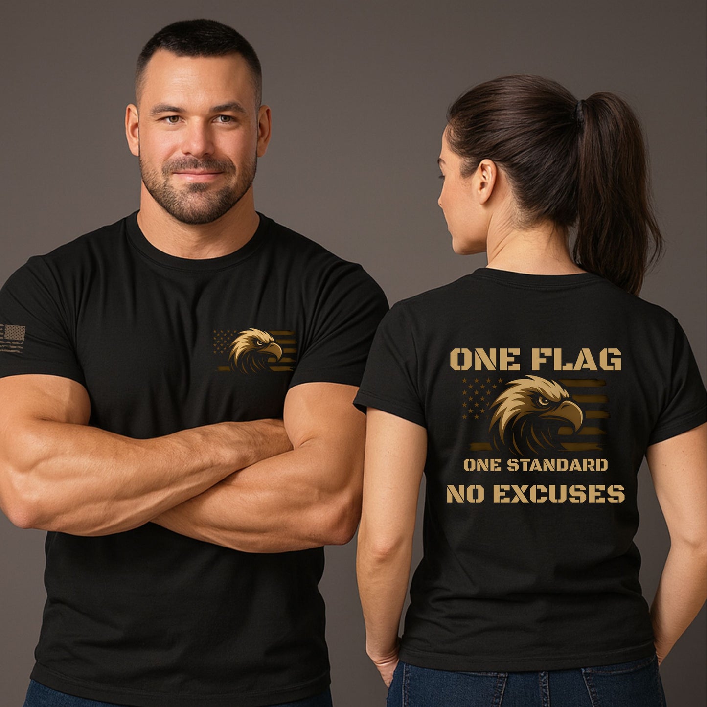 Man and woman wearing black ‘One Flag One Standard No Excuses’ t-shirts with bronze eagle and flag graphic, small chest print on front and large back print, on a gray studio background